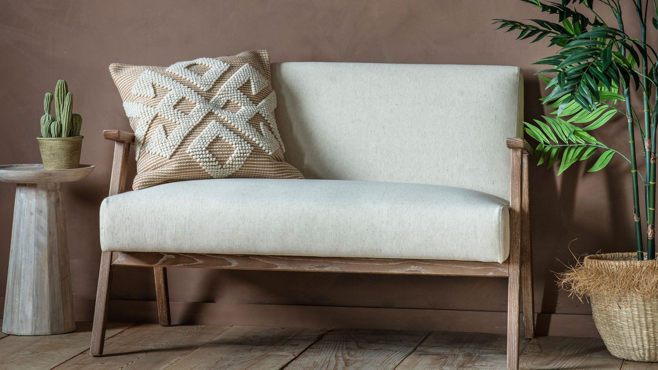 Light coloured soft linen fabric two seat sofa with natural wooden frame.