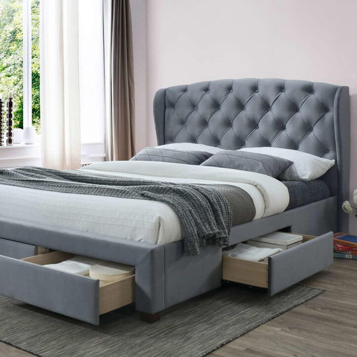 Grey fabric bed with drawers open. 
