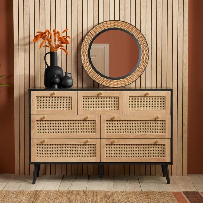 Black wooden 7 drawer chest with rattan drawer fronts.