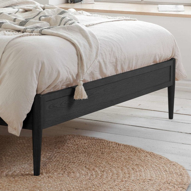 Close up of the black wooden bed footboard. 