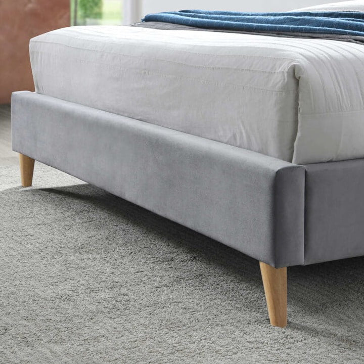 Close up of a grey fabric bed footboard