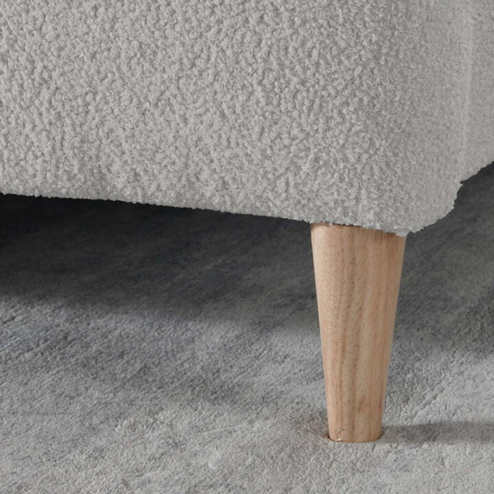 Close up of wooden feet of a grey teddy bed