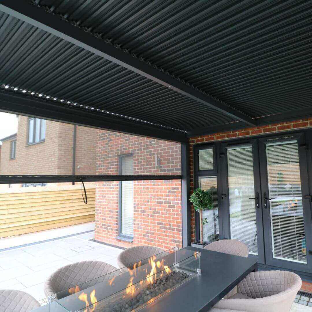 Close up of a grey aluminium pergola with louvred roof, the louvres are closed shut. 