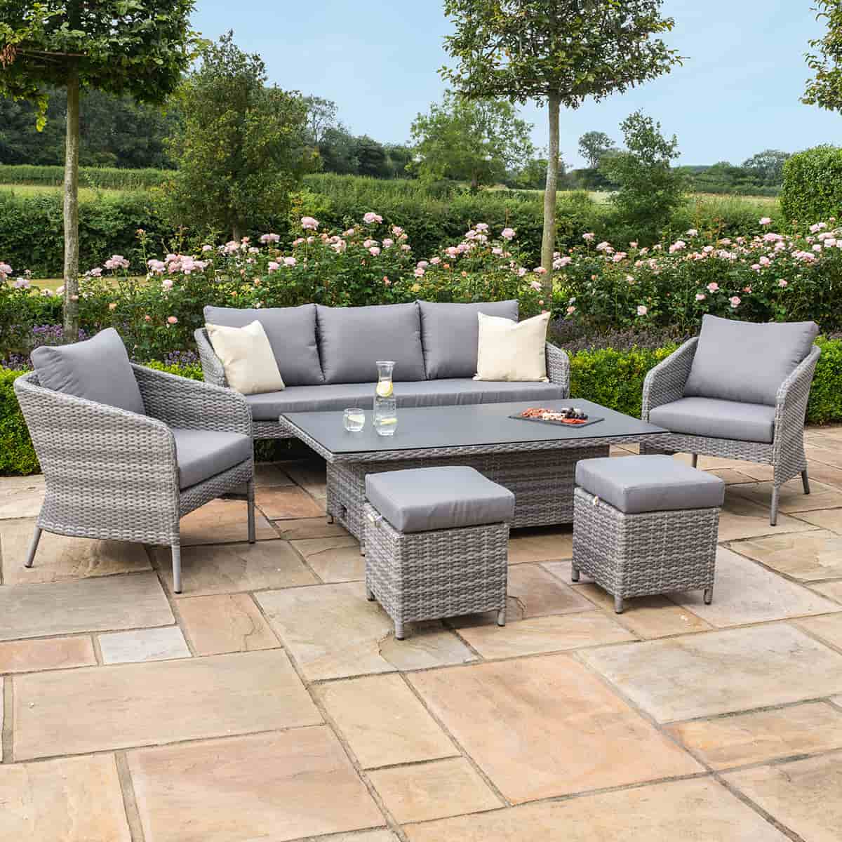Grey rattan casual sofa dining set with rectangular rising table, two chairs and two stools