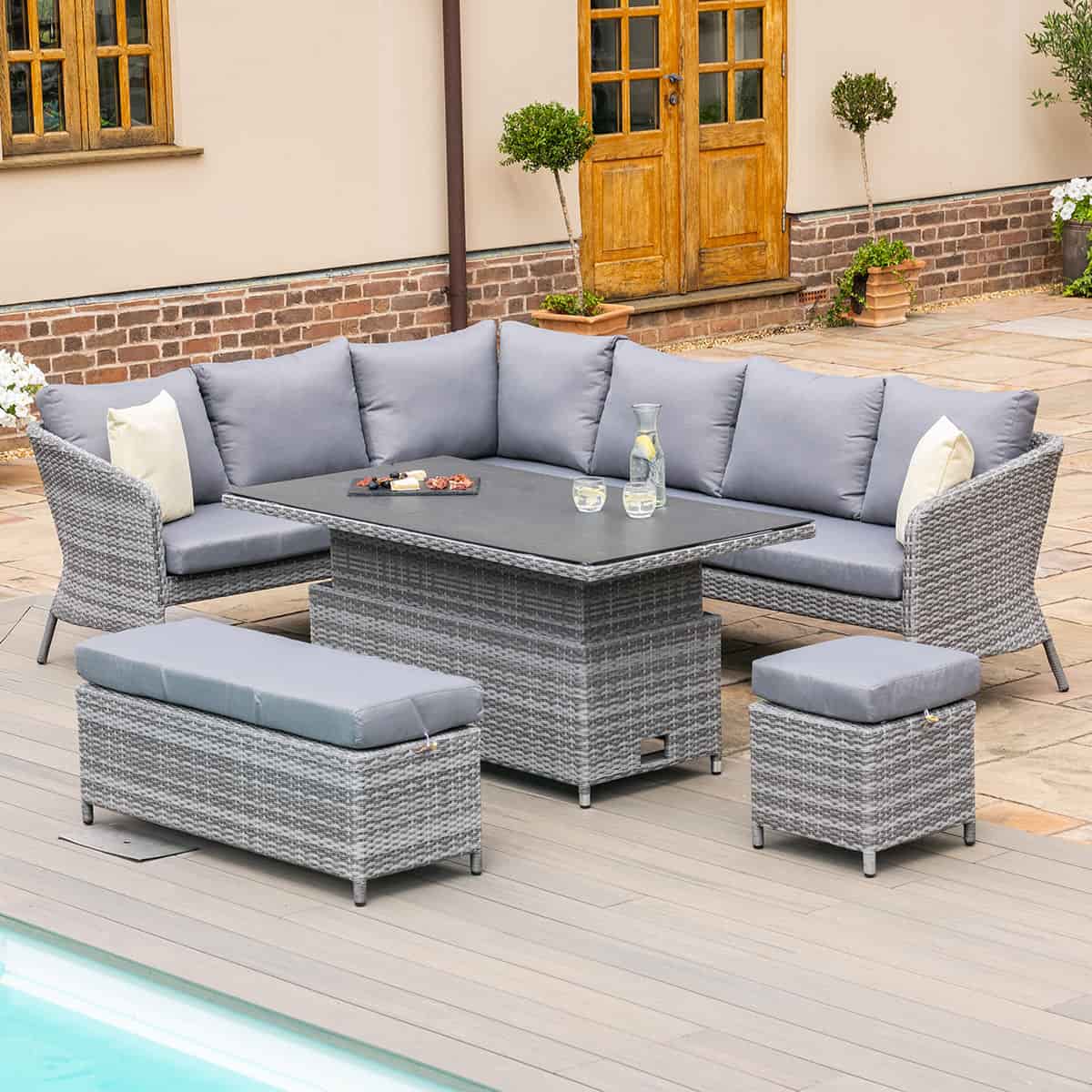Grey rattan casual corner dining set with rectangular rising table, bench and a stool