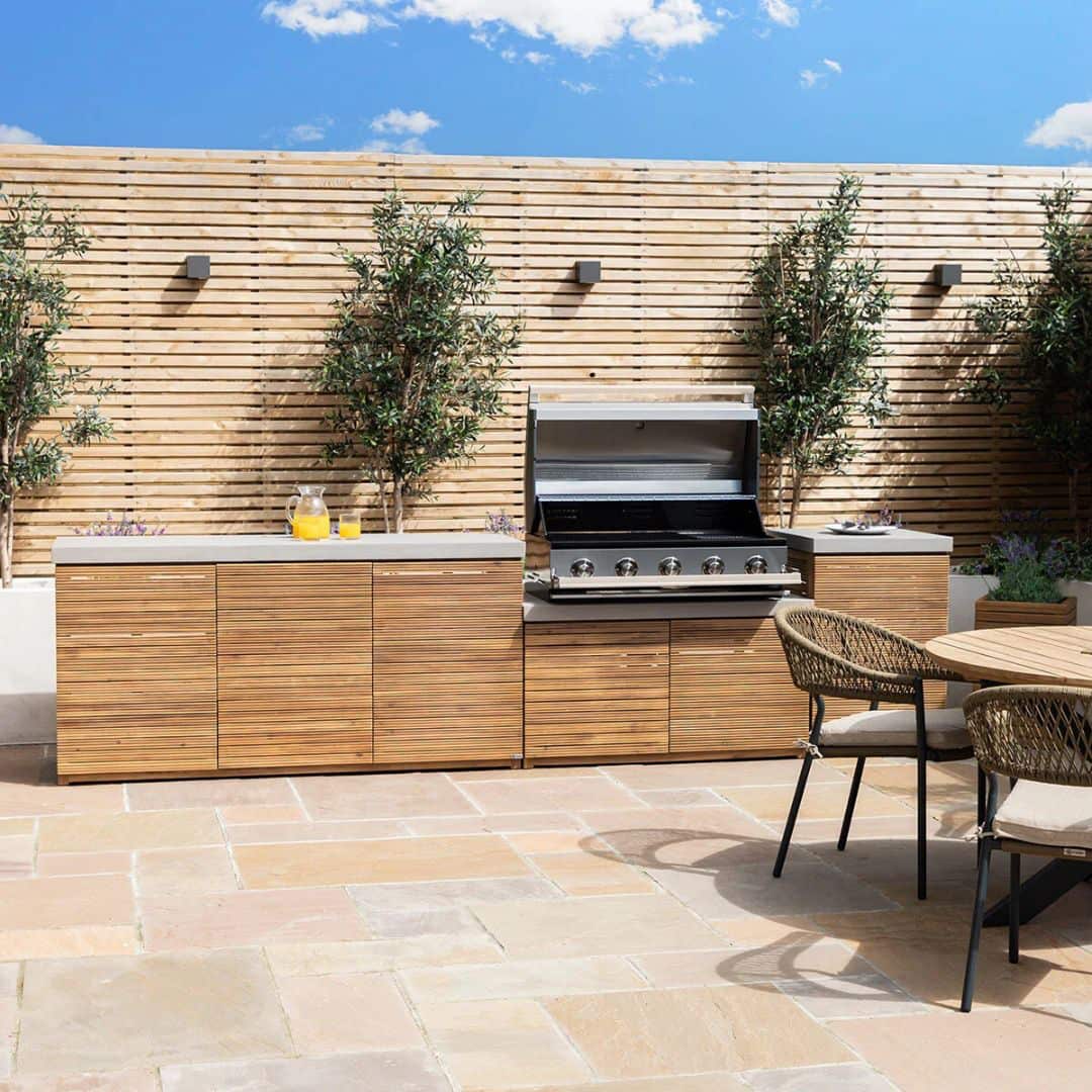 Acacia wood and a composite concrete worktop outdoor kitchen unit with bbq grill.