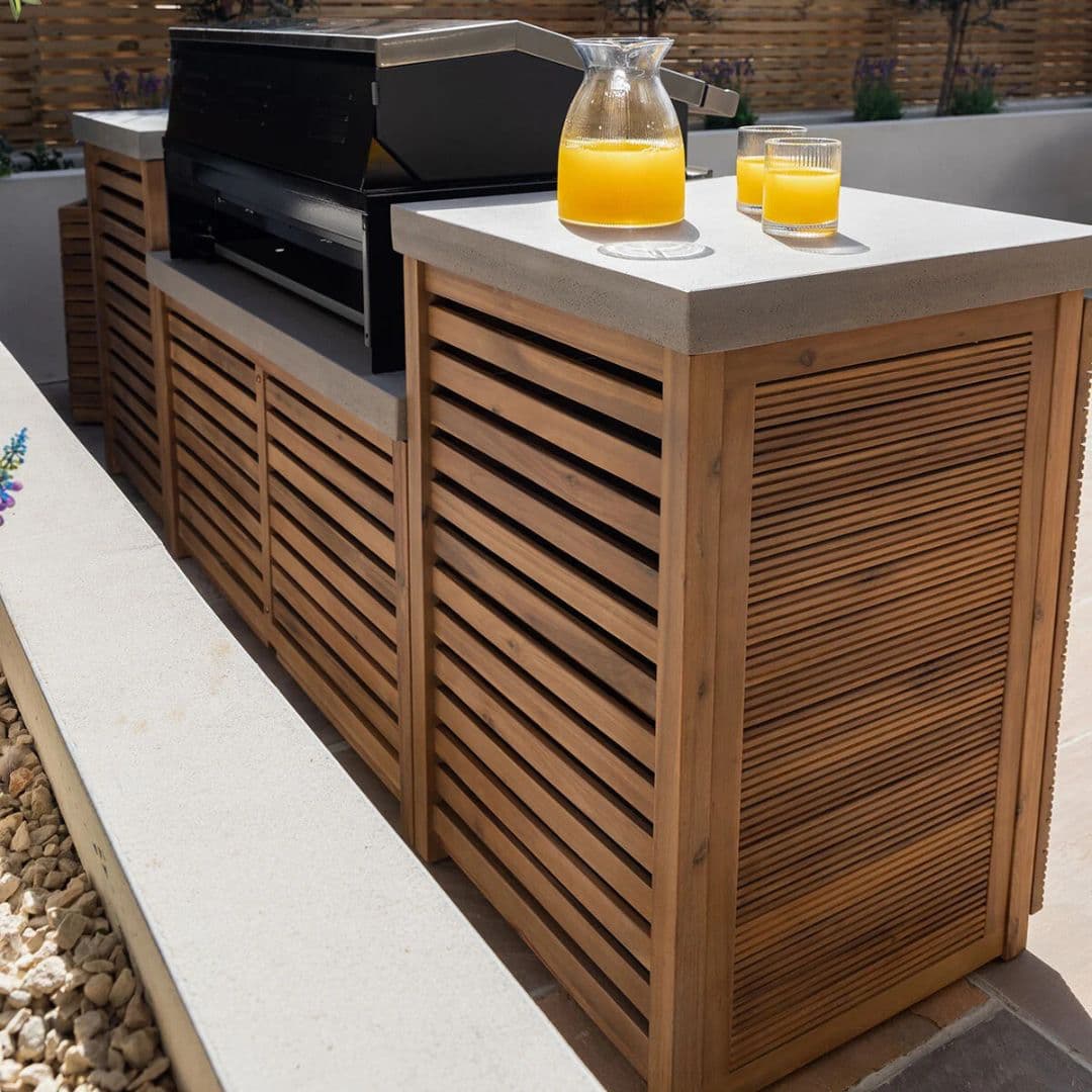 Acacia wood and a composite concrete worktop outdoor kitchen unit with bbq grill. 