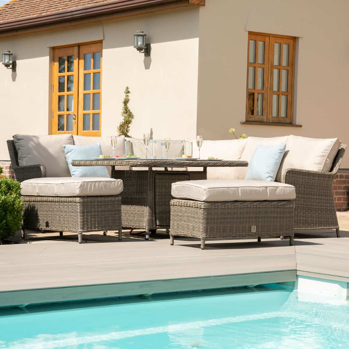 Natural coloured rattan corner sofa with two matching benches and square fire pit table.