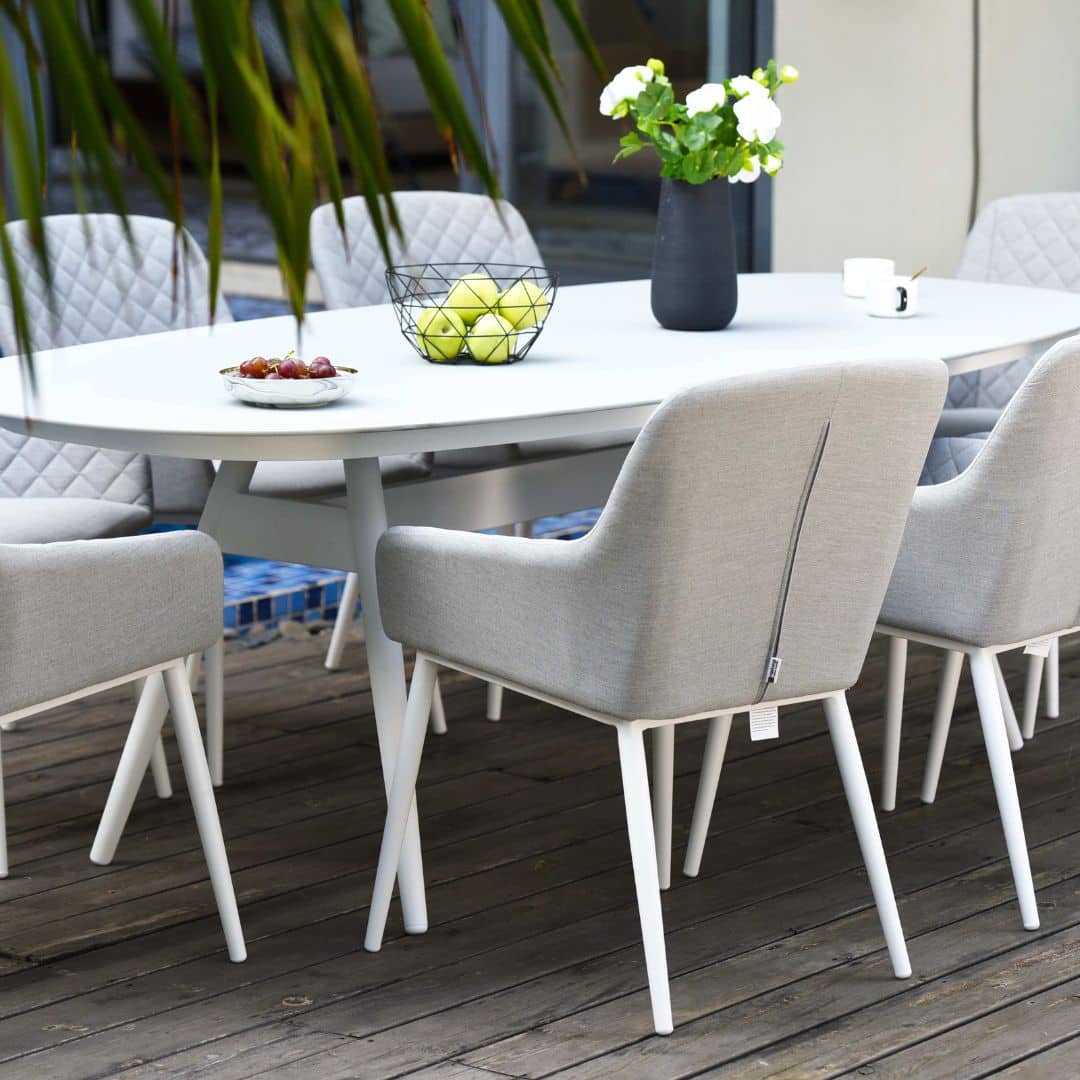 Close up of an 8 seat oval dining set with white frame and light grey fabric dining chairs #colour_lead chine
