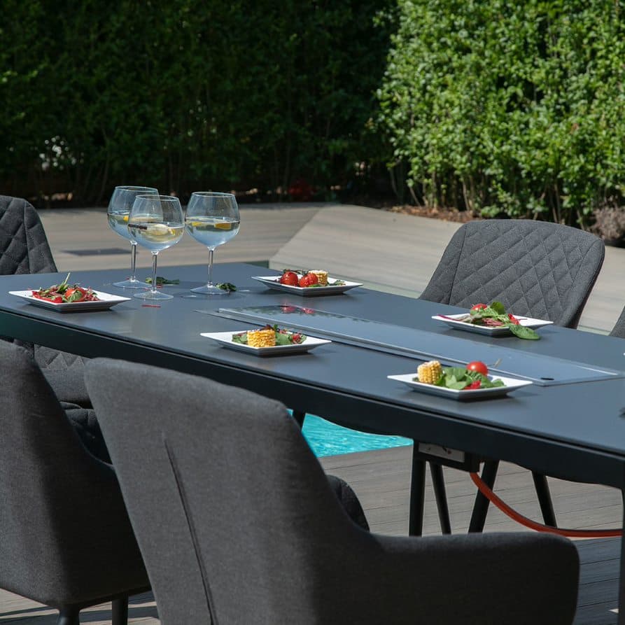 Close up of a rectangular table with fire pit closed and charcoal fabric dining chairs #colour_charcoal