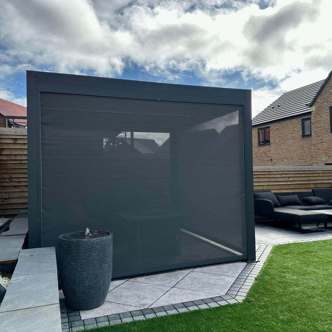 Close up of a textilene privacy screen attached to an anthracite grey aluminium pergola