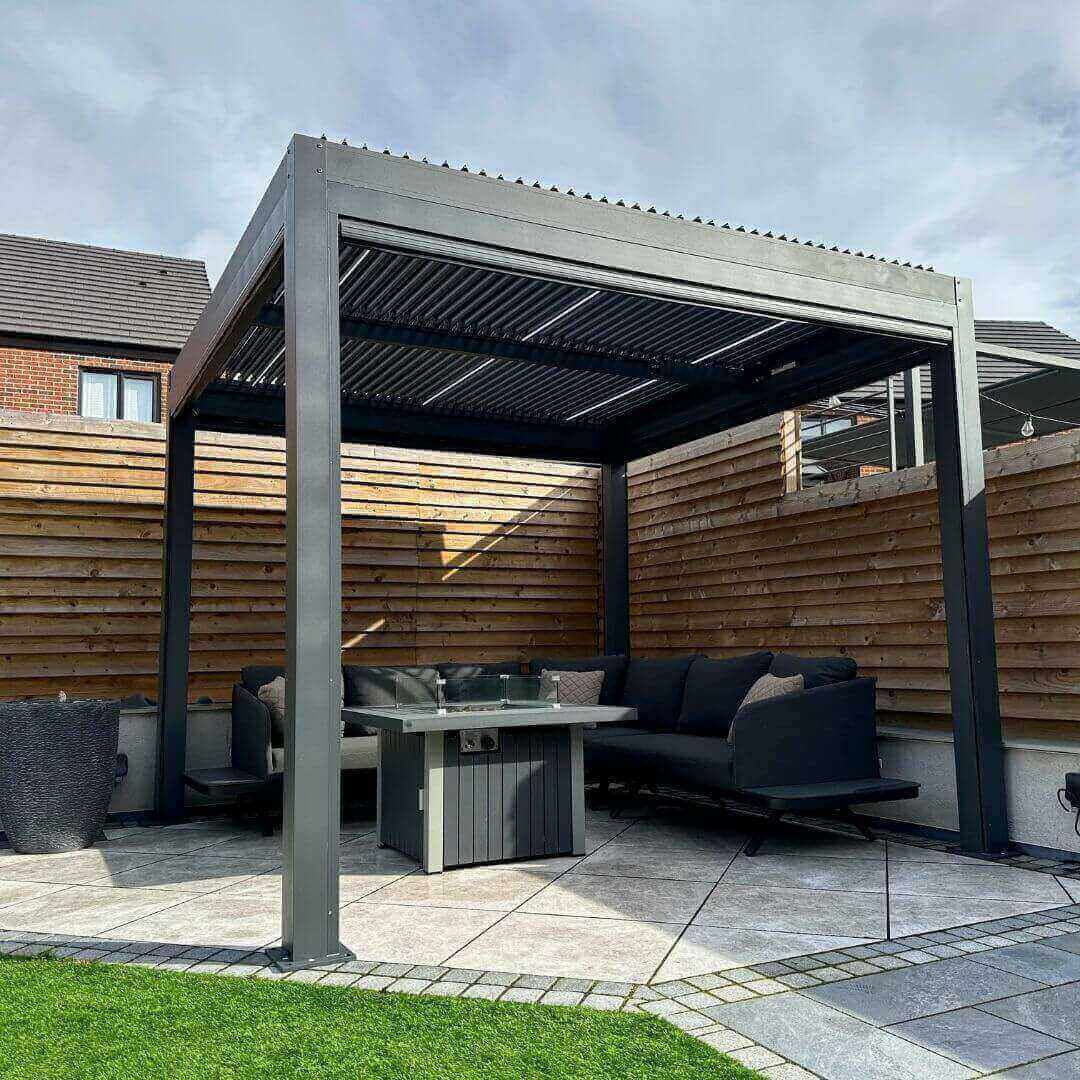 3m x 6m anthracite grey aluminium pergola with motorised louvred roof, privacy screens and white LED lights.