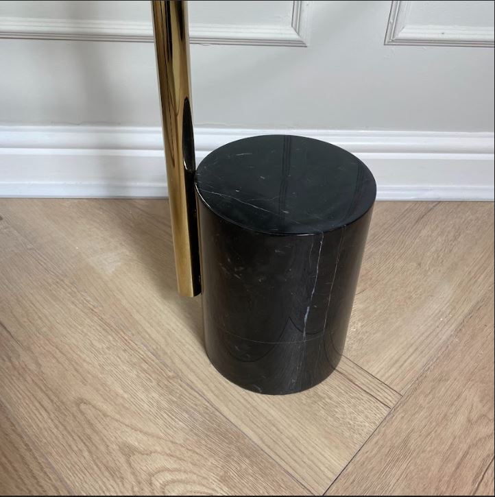 Close up of a black marble base and gold frame.