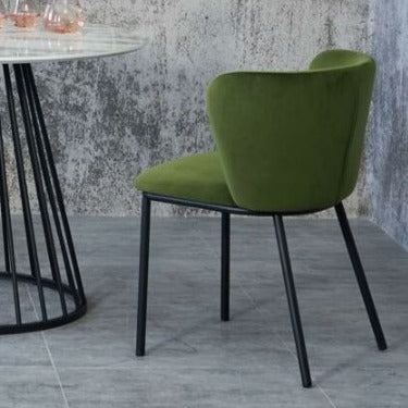 Pair of deep green velvet dining chairs with back support and black metal legs