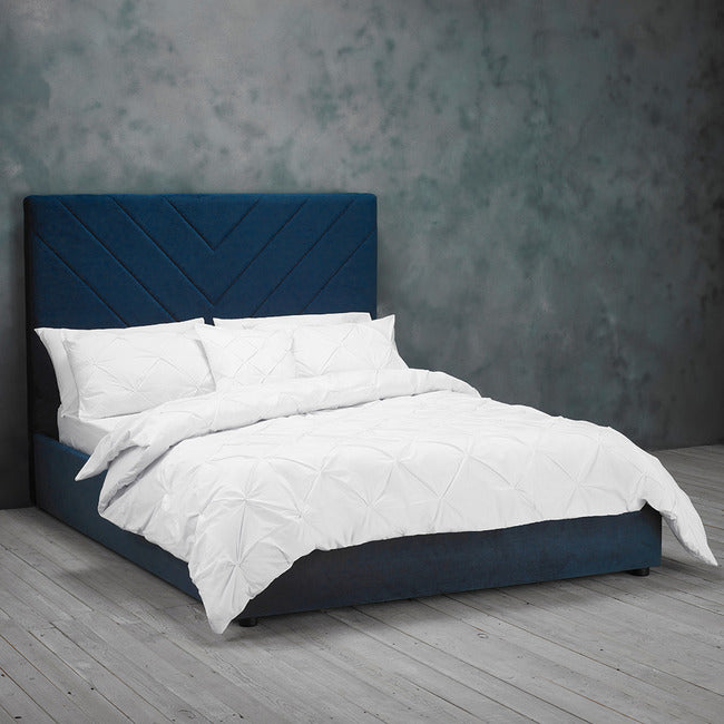 Blue velvet bed frame with v shape stitched detail headboard.