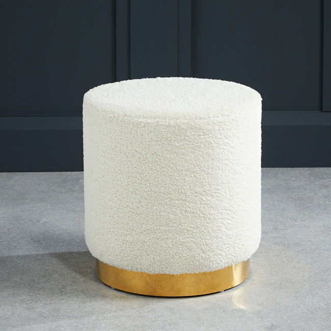 White boucle footstool with gold effect circular frame.
