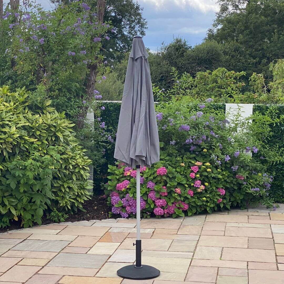 A closed grey outdoor parasol.