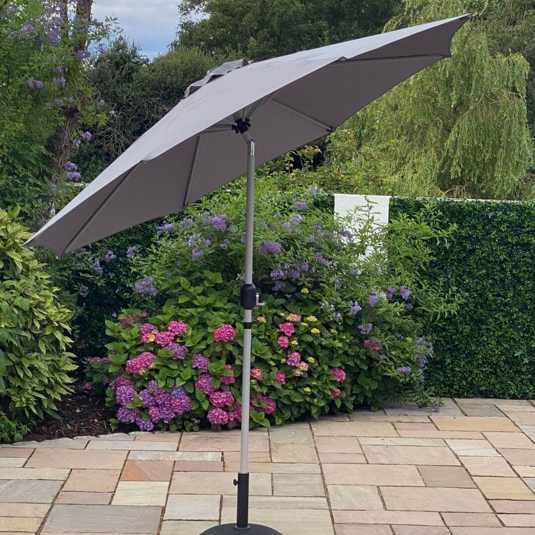 A grey outdoor parasol on a tilt.