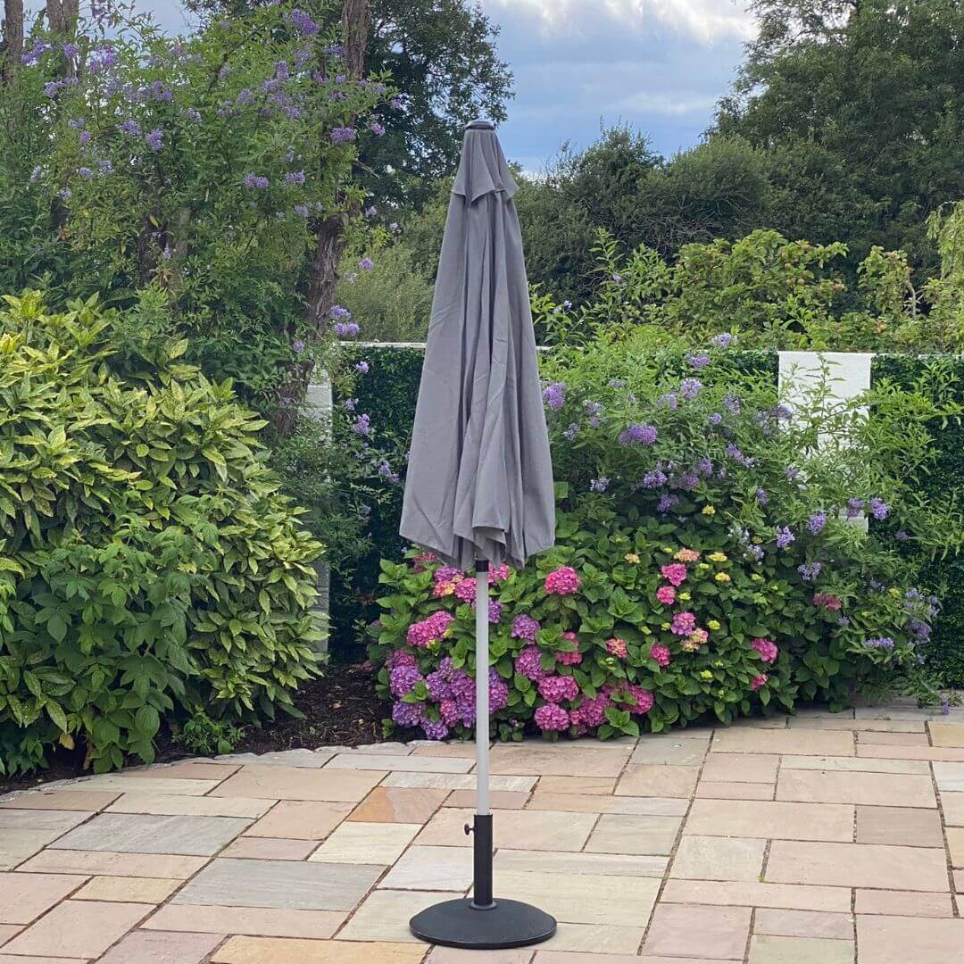 A closed grey outdoor parasol.
