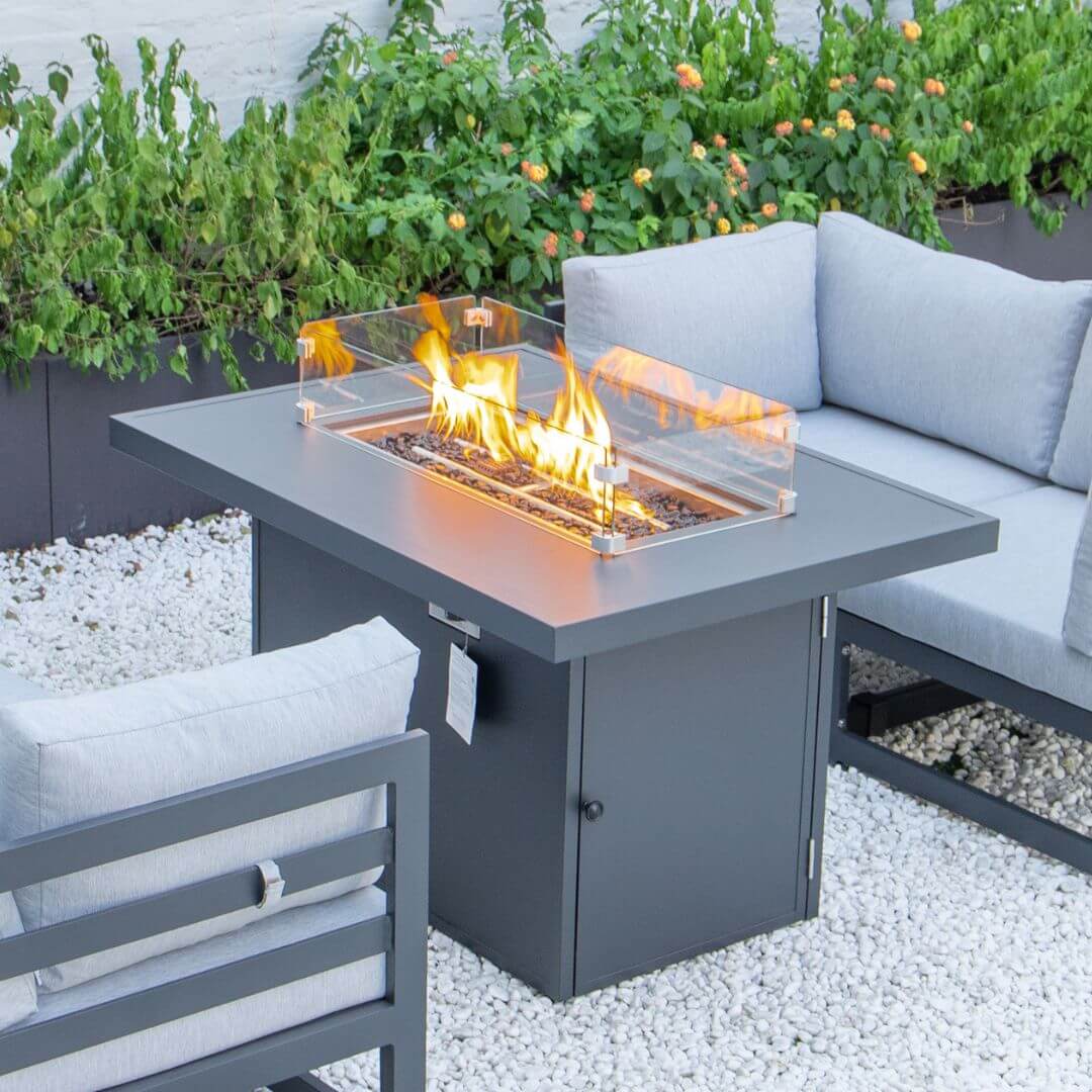 Close up of the grey aluminium fire pit table. The fire pit is turned on.