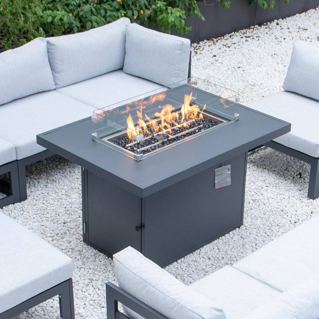 Close up of a grey aluminium rectangle fire pit table. The fire pit is turned on.