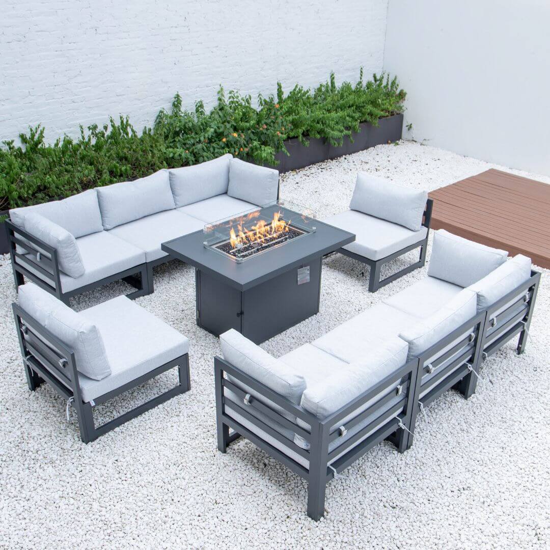 A grey aluminium 8 seat sofa set with fire pit table. Features two 3 seat sofas, two single armchairs and a matching rectangle fire pit table in the centre. The fire pit is turned on.