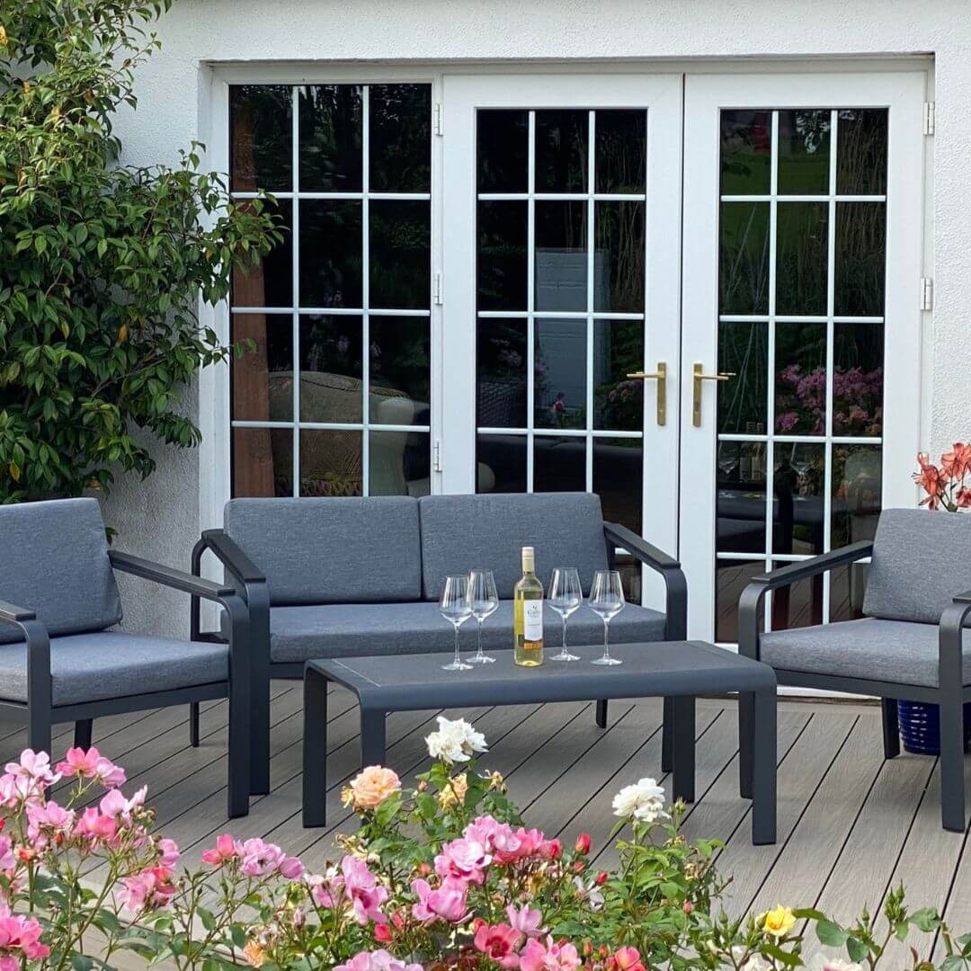 A dark grey aluminium 4 seat sofa set with a two-seat sofa, two single armchairs and a matching rectangle coffee table.