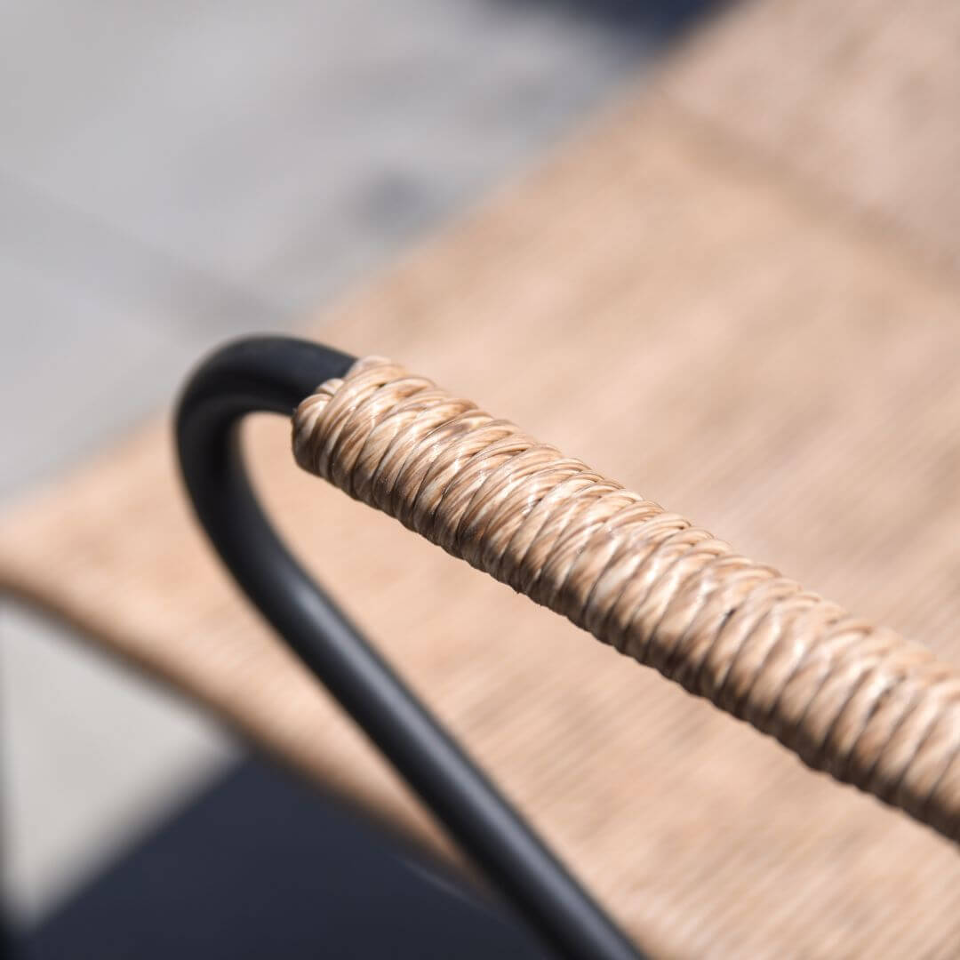 Close up of a wicker dining chair arm.