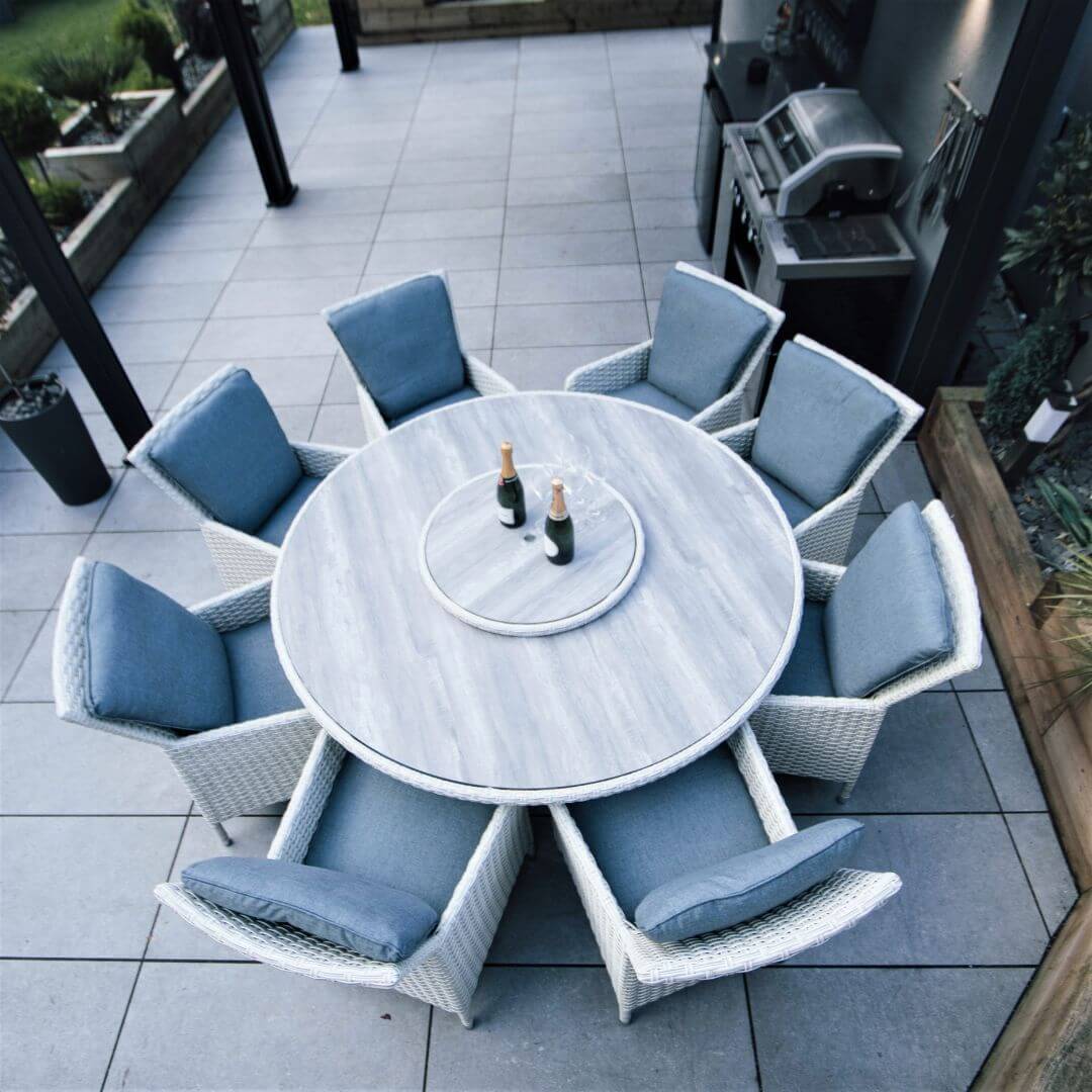 Overhead view of a light grey rattan 8 seat round dining set with ceramic printed glass table top and lazy susan.