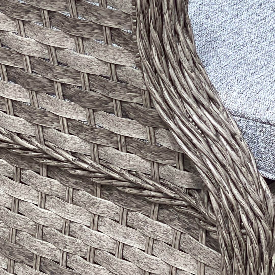 Close up of an arm of a dark grey rattan armchair.