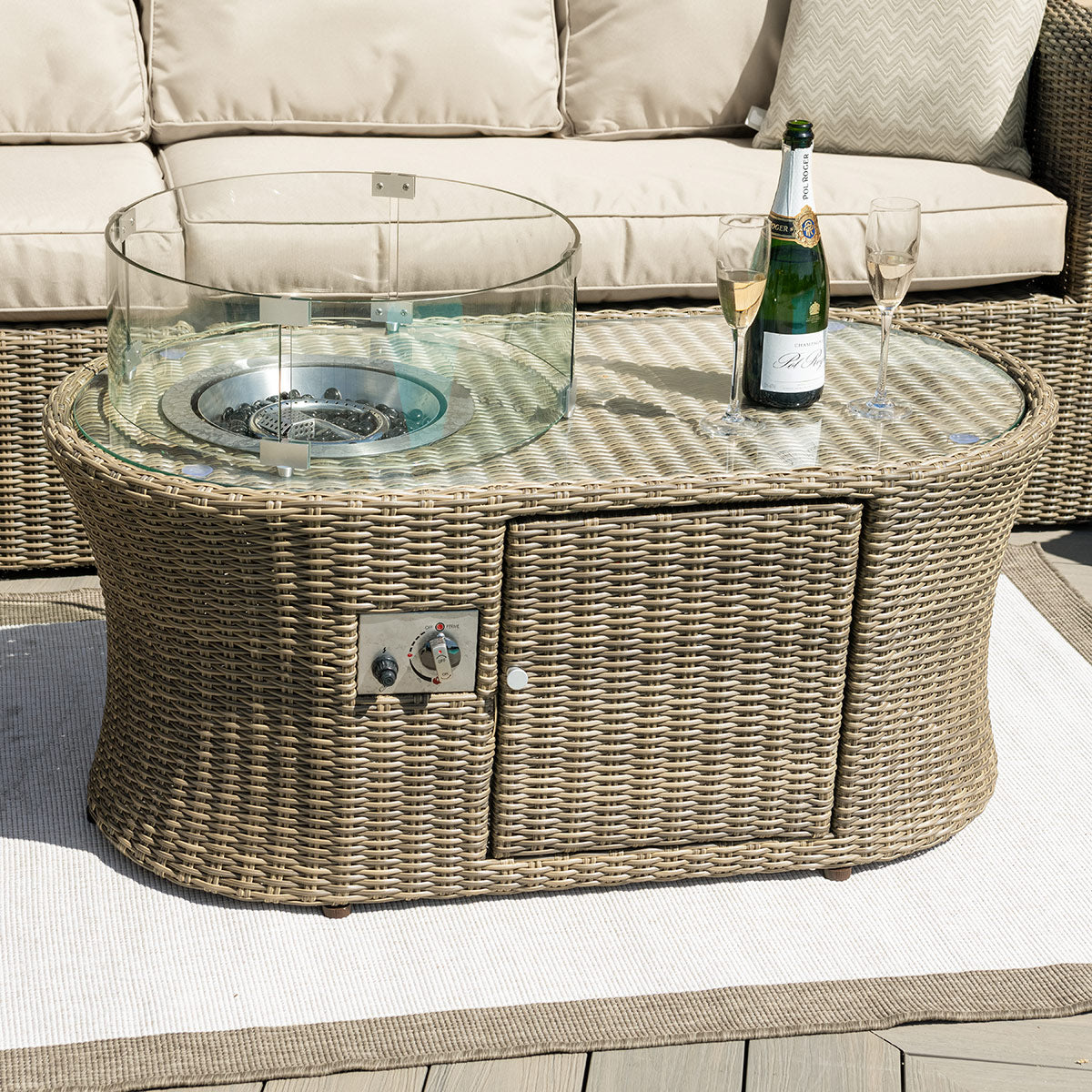 Close up of a natural coloured rattan oval fire pit coffee table.