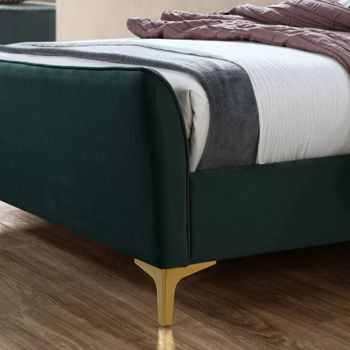 Close up of a green fabric footboard and gold feet #colour_green